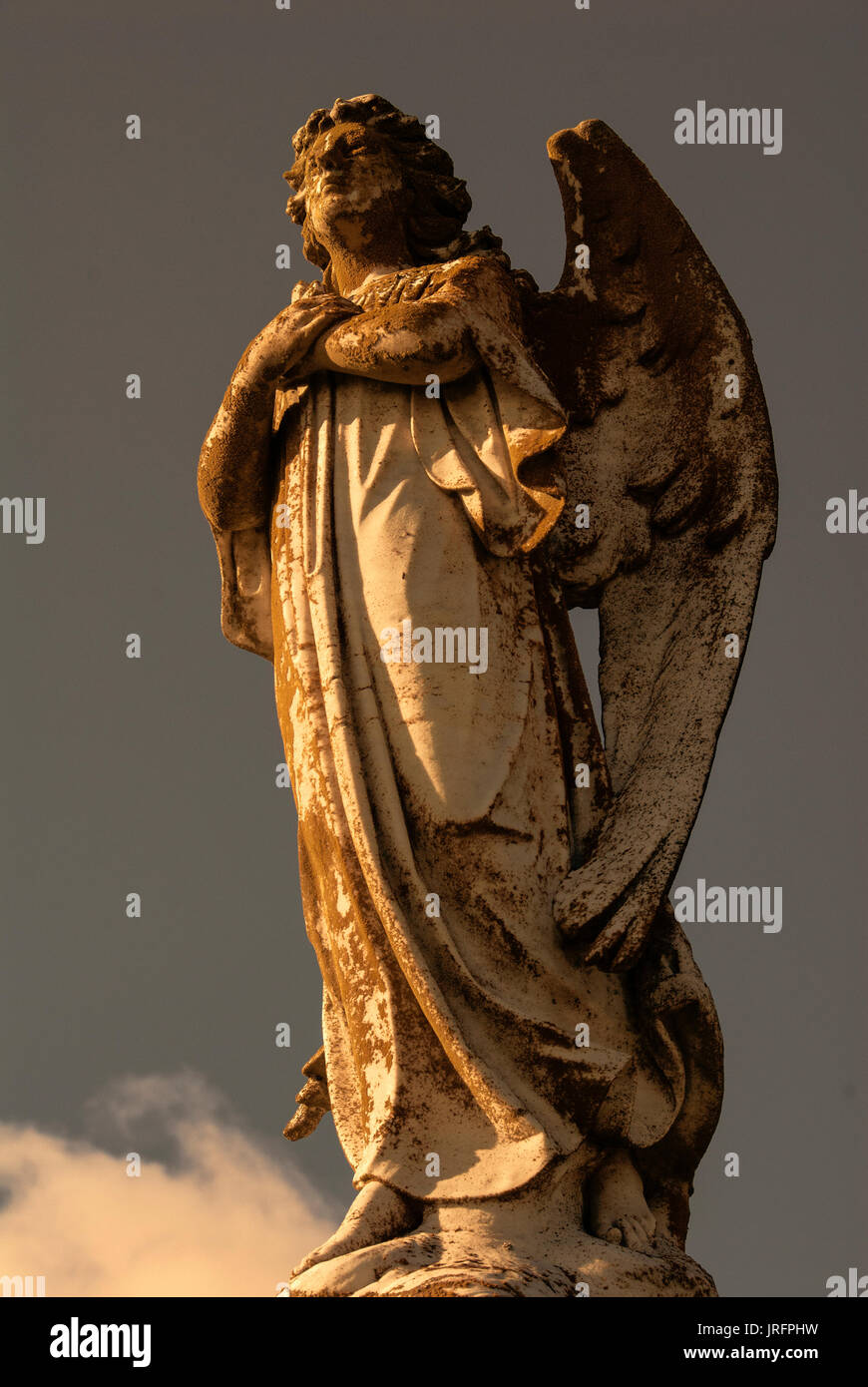 A statue of a male angel in the clouds. Stock Photo