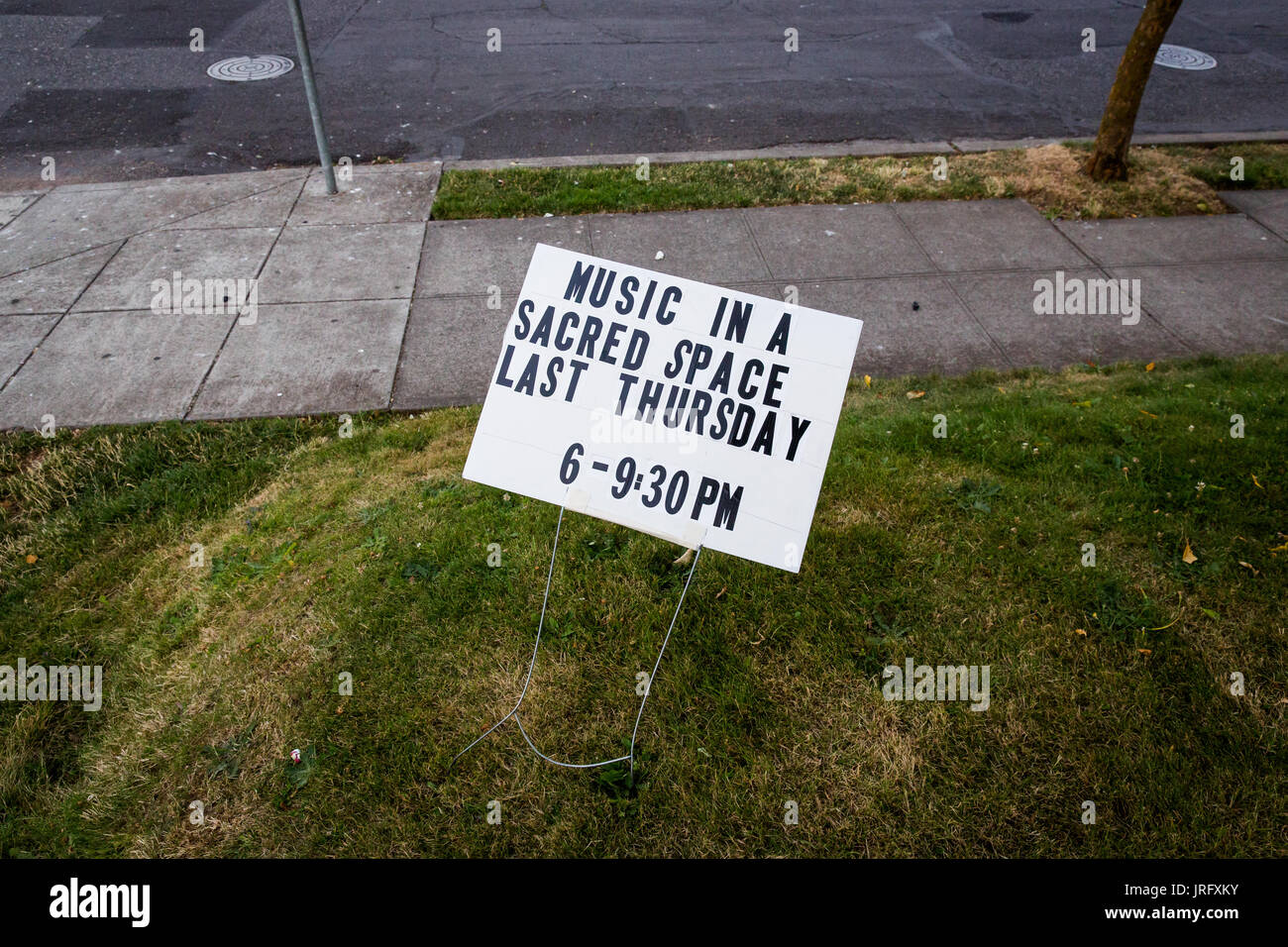 Lawn sign in Portland Oregon that reads: 'Music is a sacred space, Last Thursday 6-9:30pm' Stock Photo
