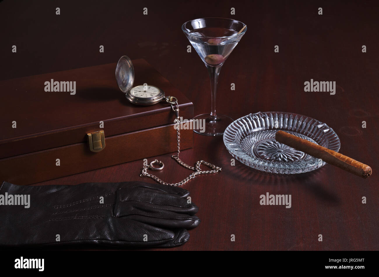 Cigarbox, pocket watch, Martini, Cuban cigar and leather gloves. Vintage gentlemens theme Stock Photo