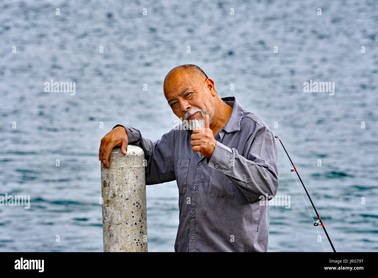 A fisherman posing with thumps up Stock Photo
