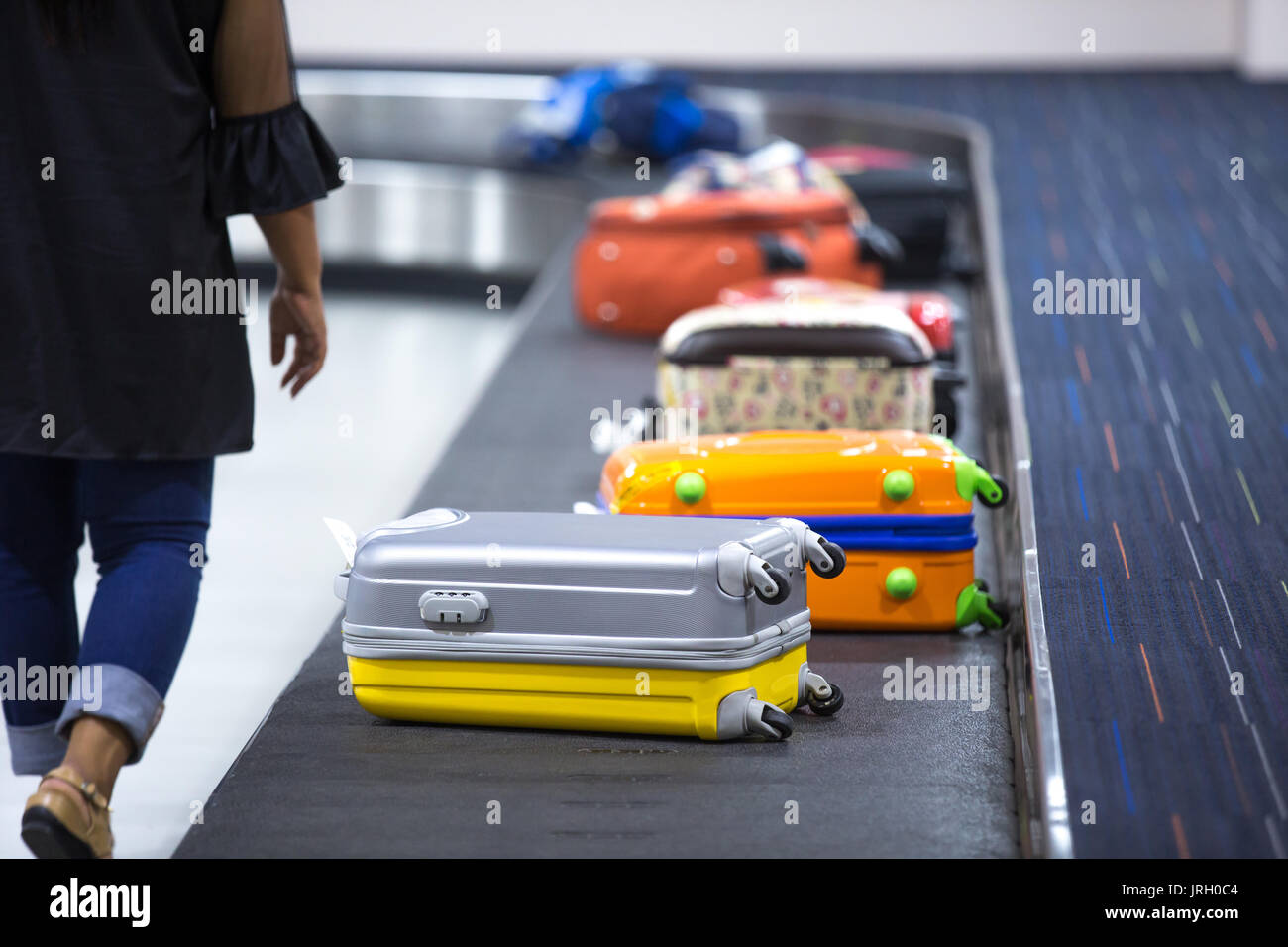 Wheeled suitcase on a luggage belt at the airport terminal Stock Photo