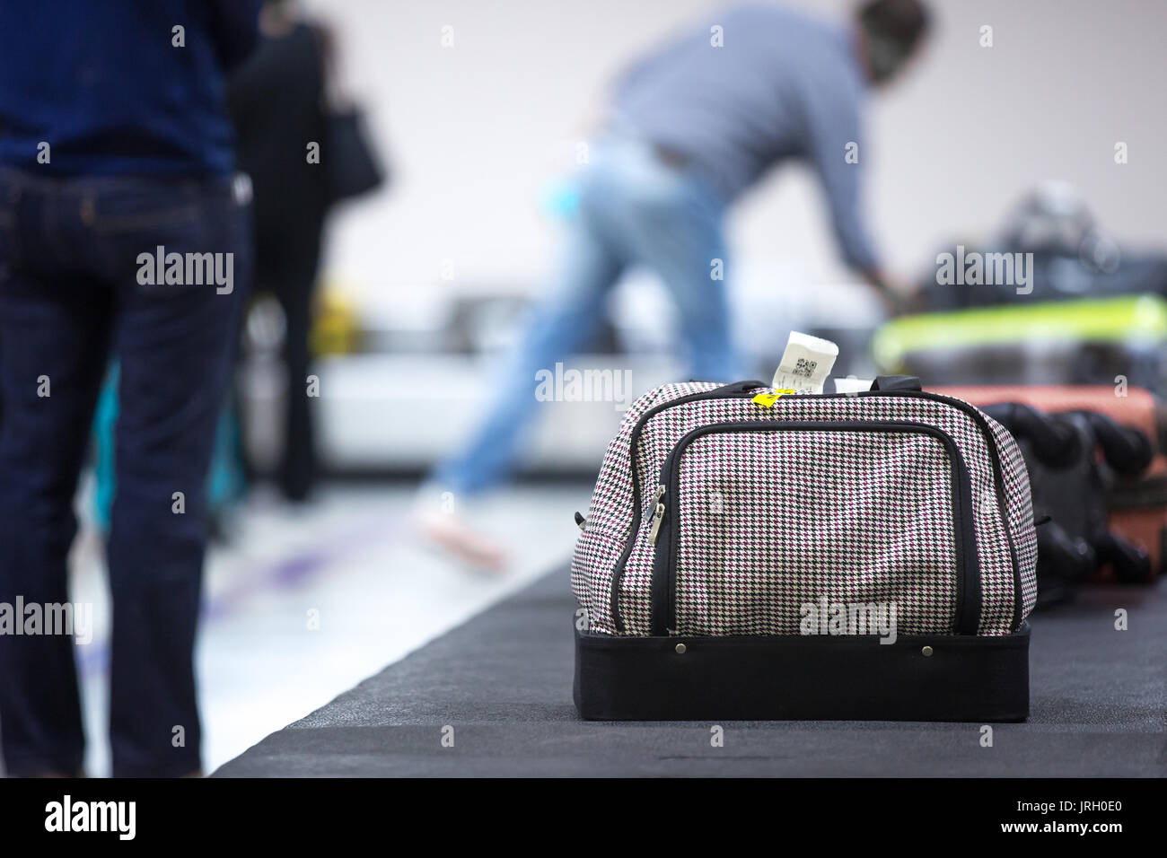 Wheeled suitcase on a luggage belt at the airport terminal. Stock Photo