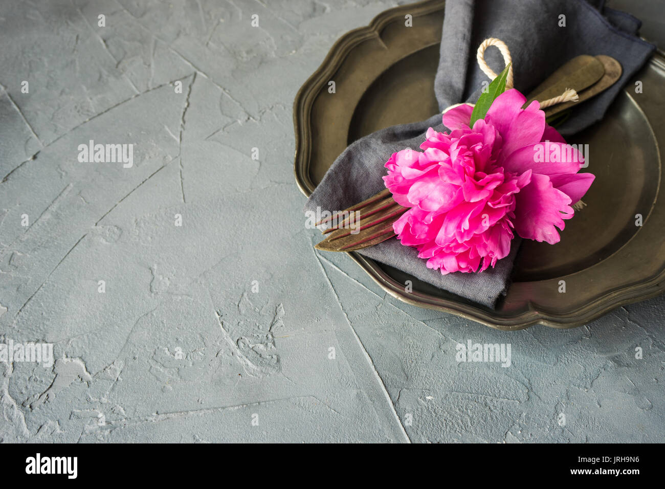 Summer table setting with bright peonies on dark rustic table with copyspace Stock Photo