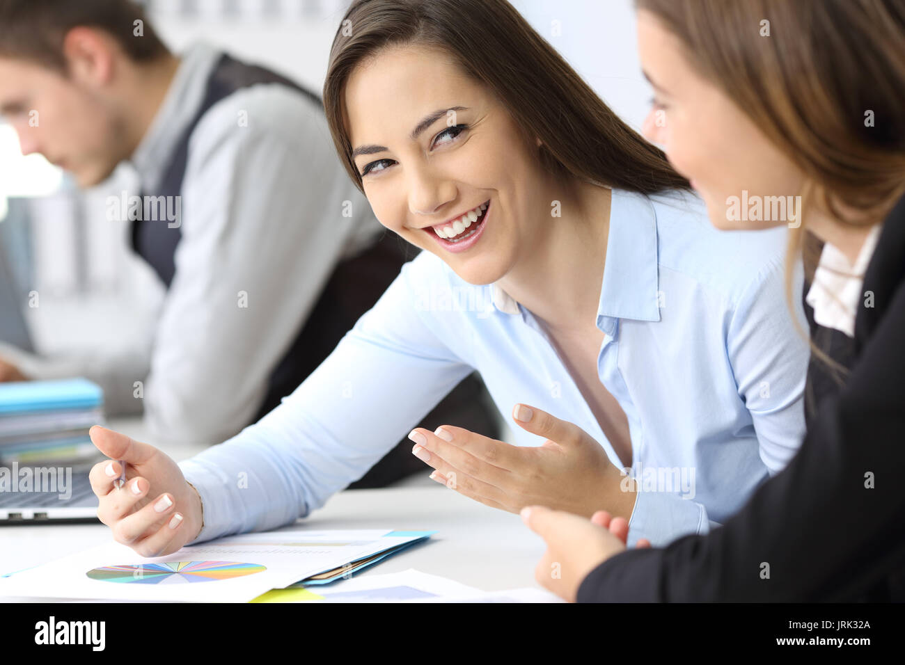 Two businesswomen talking about work at office Stock Photo