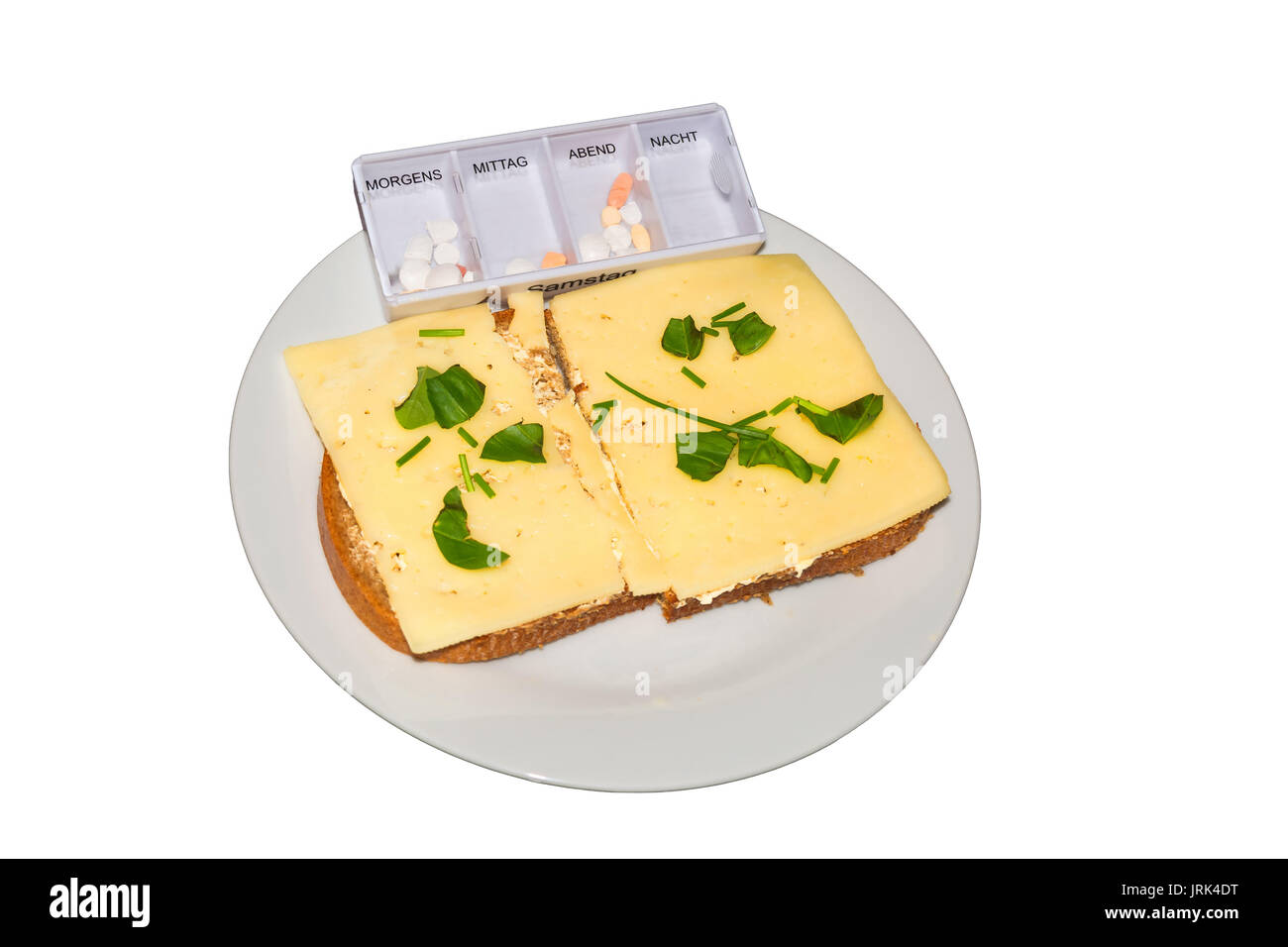 Simple cheese bread with fresh herbs and a medicine box on a white plate against neutral background. Stock Photo