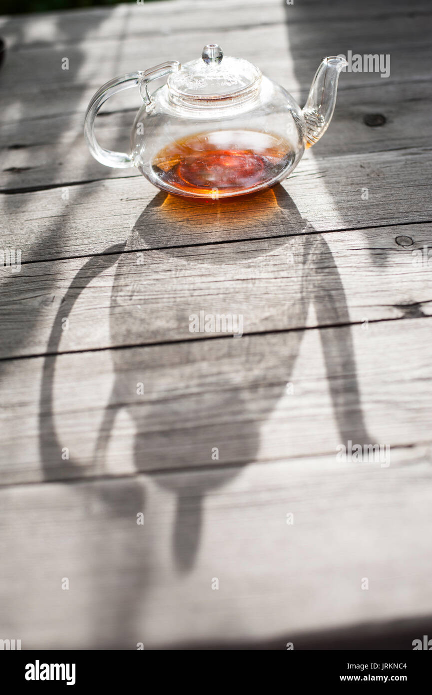 Traditional Chinese tea ceremony - Chinese glass teapot filled with red tea on wooden table Stock Photo
