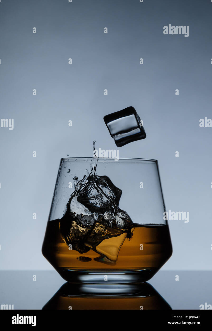 whiskey on the rocks with ice cubes and splash Stock Photo - Alamy