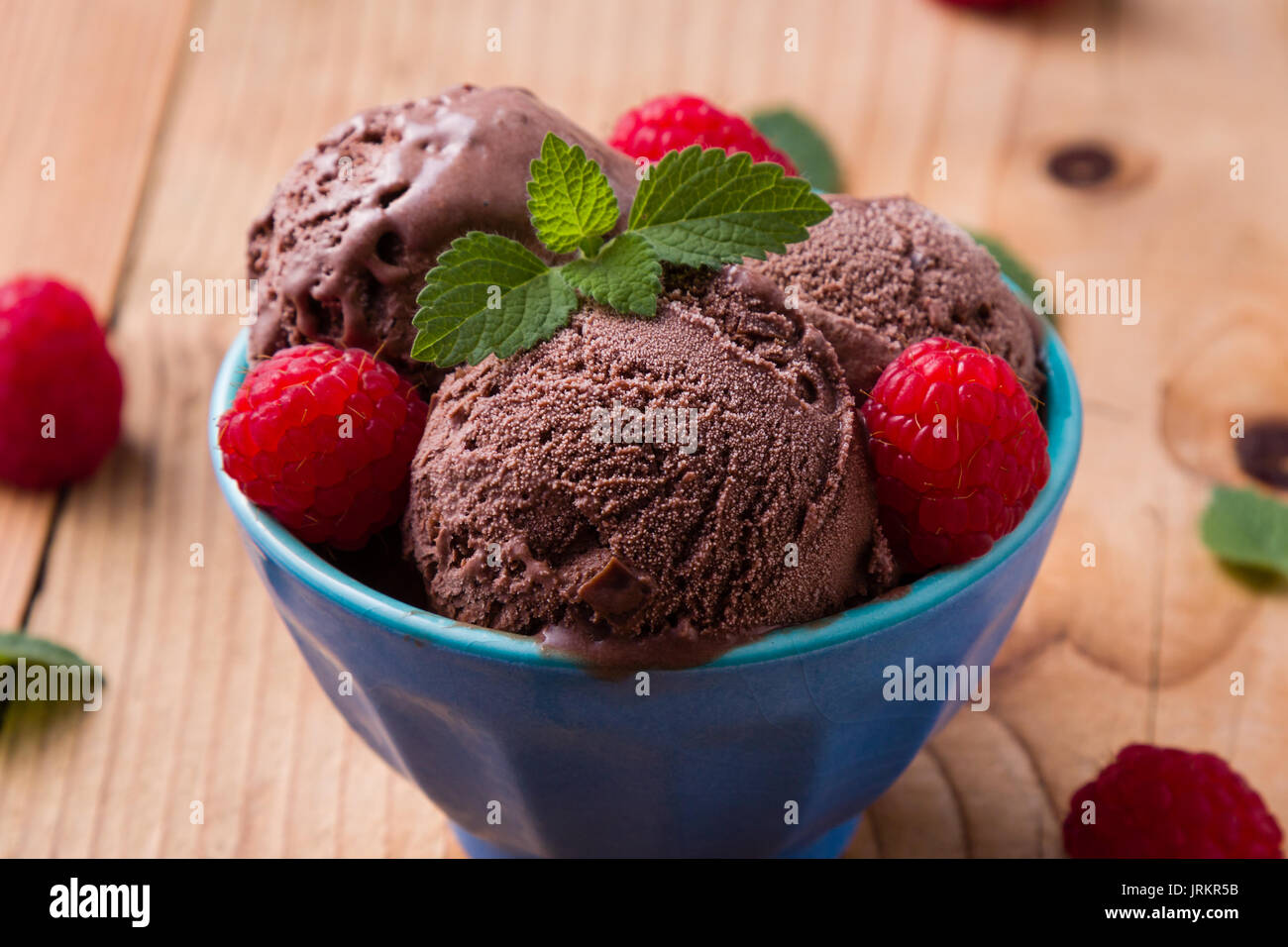 chocolate ice cream in blue bowl with raspberries Stock Photo - Alamy