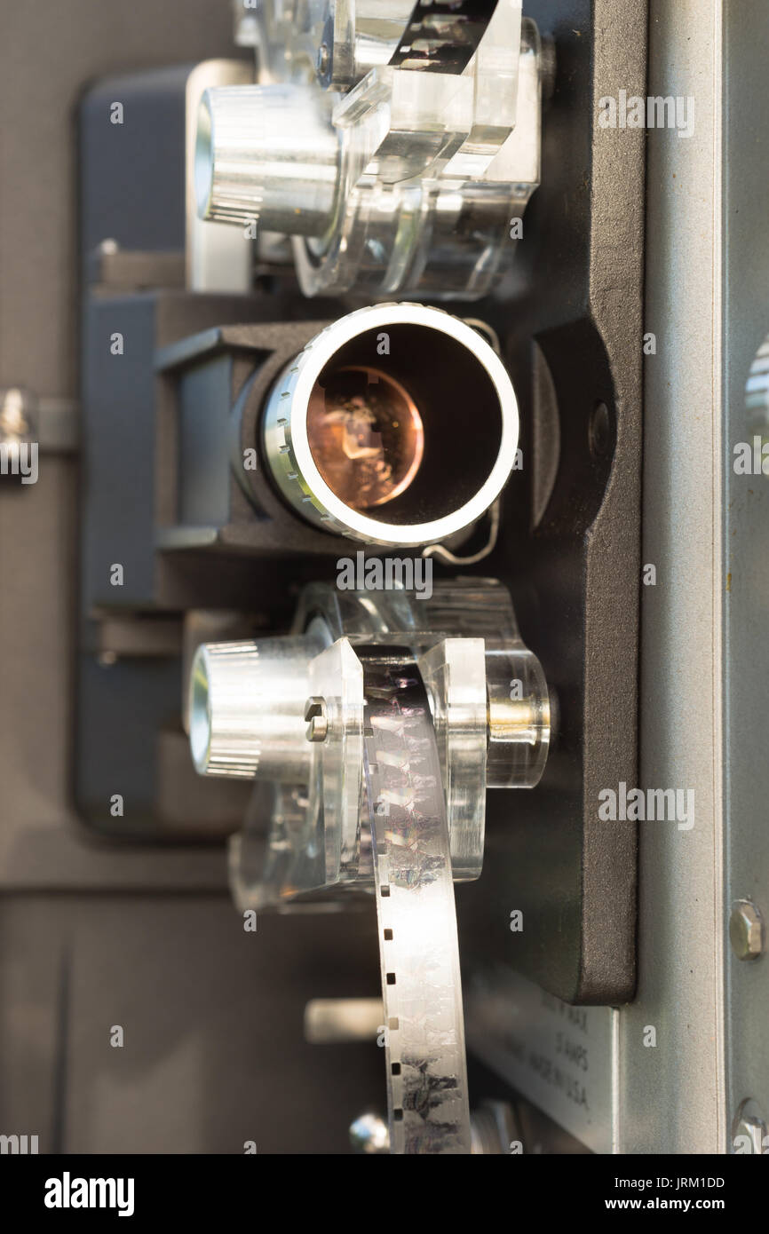 A large film reel is mounted on a vintage Super 8 movie projector