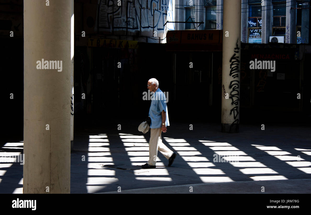 Belgrade, Serbia - April 6, 2017:  Senior man walking alone in the city street passage in motion blur Stock Photo