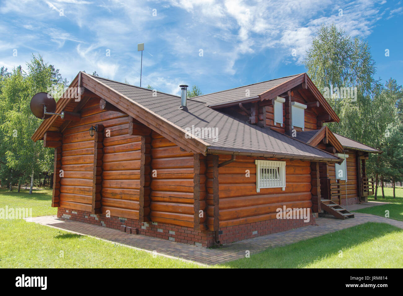A modern wooden house made of logs. View from outside in summer Stock Photo