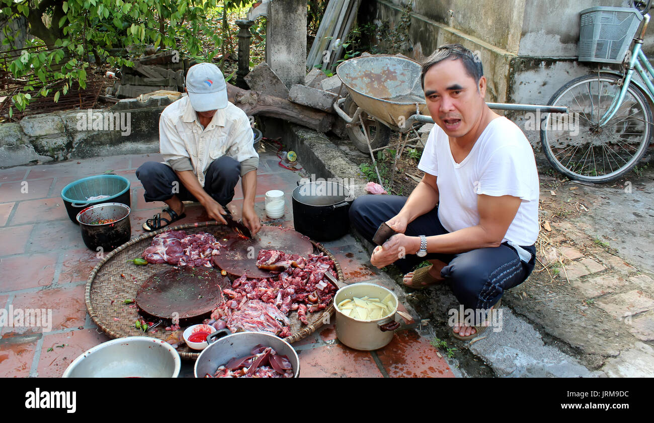 HAI DUONG, VIETNAM, November, 20: Asian men slaughtering dog to cook on November 20, 2013 in Hai Duong, Vietnam. Stock Photo
