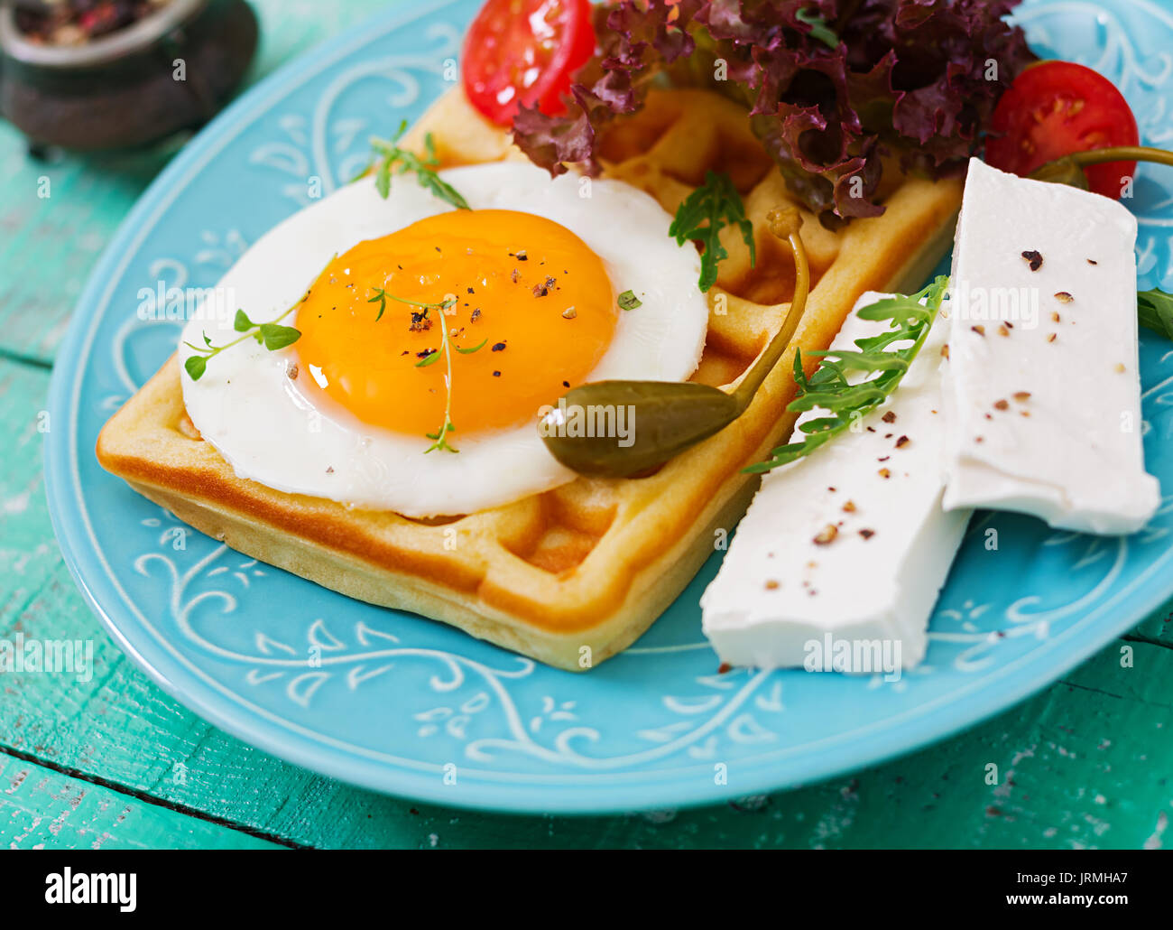 Healthy breakfast waffles, eggs, feta cheese, tomatoes and lettuce