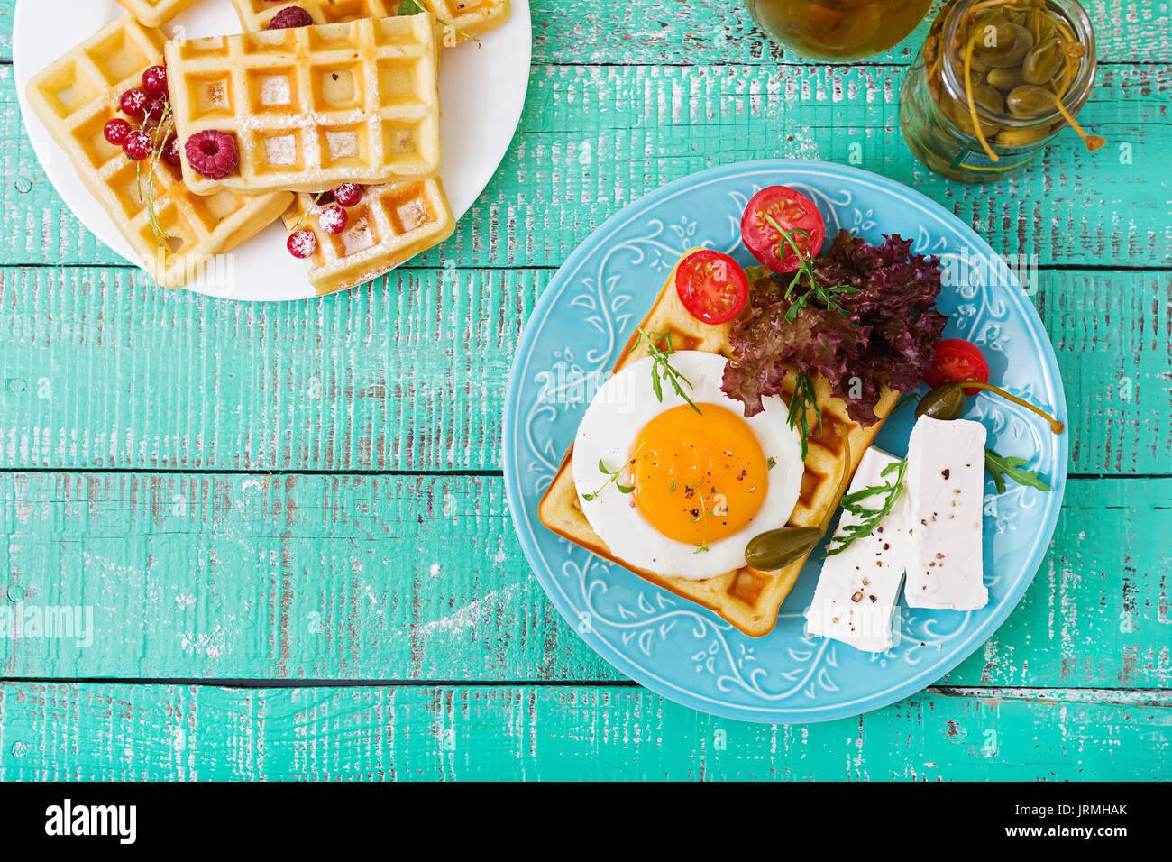 Healthy breakfast waffles, eggs, feta cheese, tomatoes and lettuce