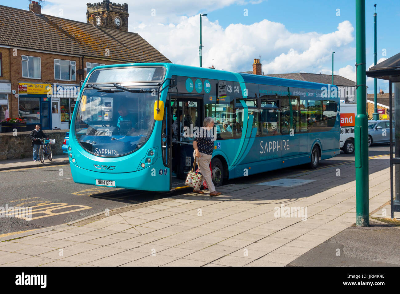 A lady alighting from an Arriva Sapphire bus providing a 15 minute interval service on selected routes countrywide here in Marske by the sea Yorkshire Stock Photo