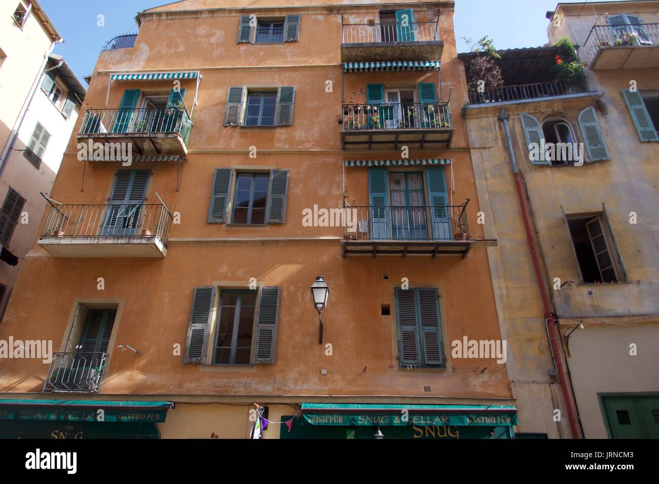 Old town apartment exterior with window shutters and balconies, Nice, France Stock Photo