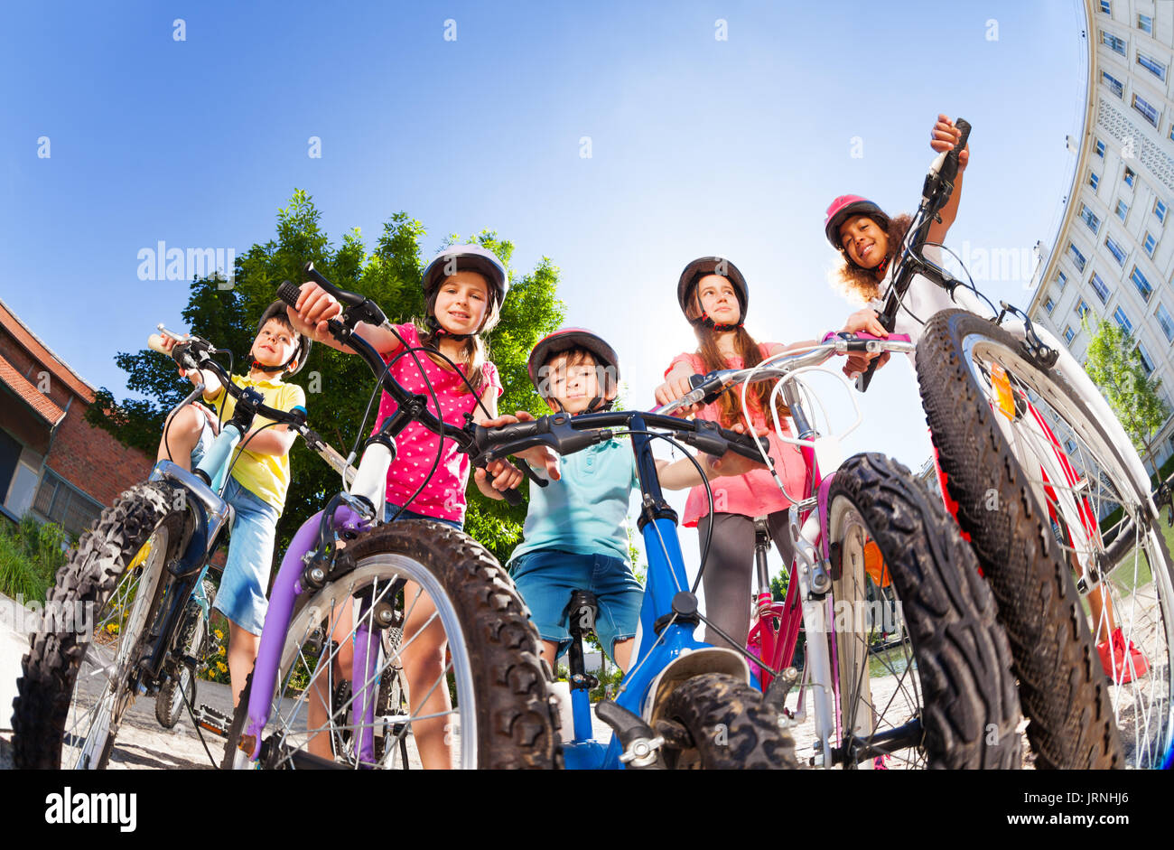 Low angle portrait of five happy bike riders, two boys and three girls ...