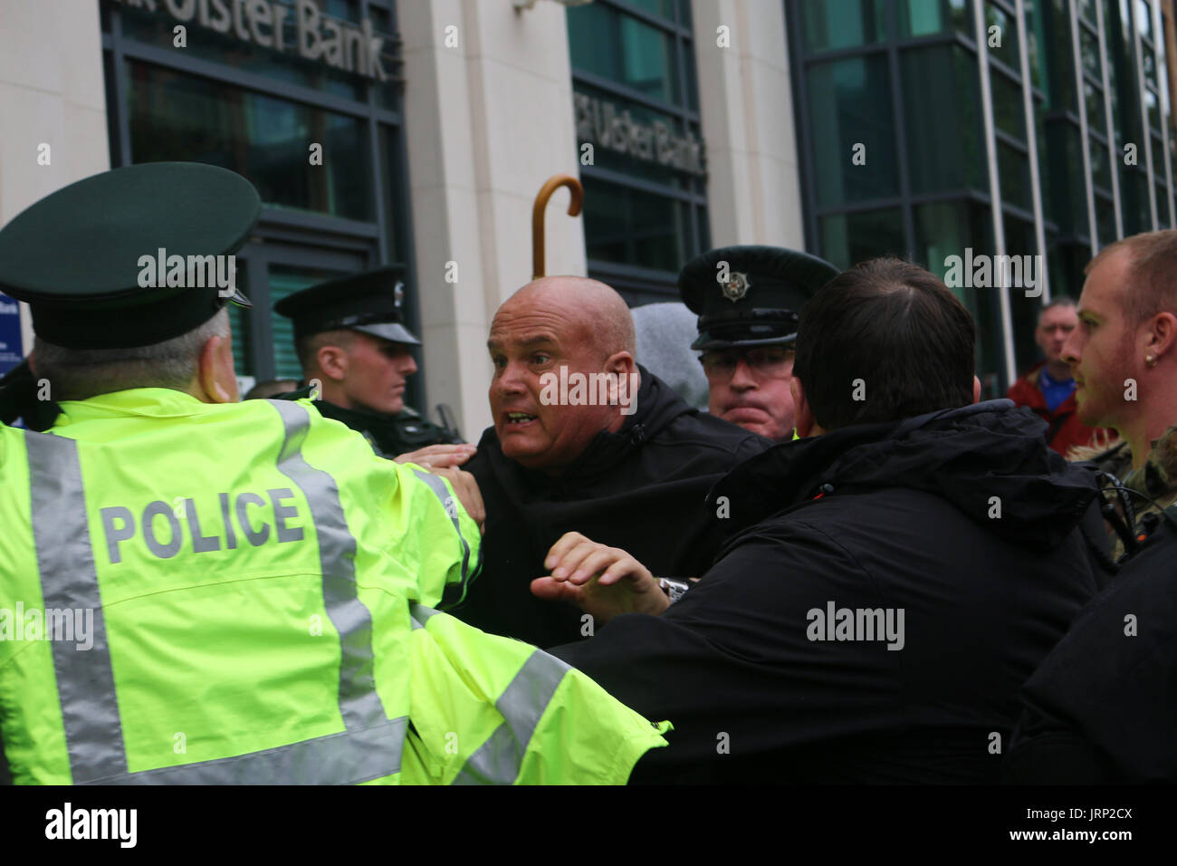 Belfast, UK. 06th Aug, 2017. A man is held back by police after an object was thrown at a Britain first rally in Belfast Credit: Conall Kearney/Alamy Live News Stock Photo