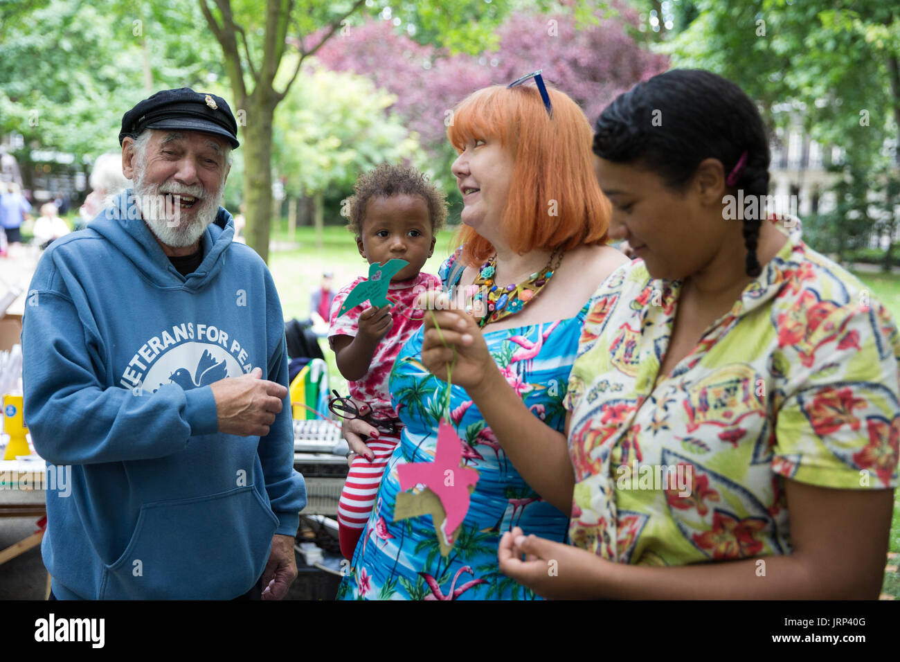 London, UK. 6th August, 2017. Jim Radford, D-Day veteran, folk singer and peace campaigner with Veterans for Peace, shares a joke with peace campaigners posting messages to Prime Minister Theresa May on the commemorative Hiroshima cherry tree during the annual Hiroshima Day anniversary event in Tavistock Square. Credit: Mark Kerrison/Alamy Live News Stock Photo