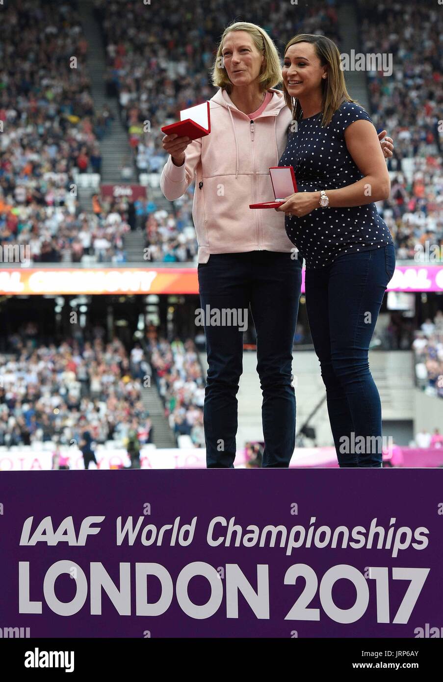 Leichtathletik: IAAF Weltmeisterschaft am 06.08.2017 im Olympiastadion in London (Großbritannien). Die frühere Siebenkämpferin Jennifer Oeser (l) aus Deutschland erhält nachträglich die Silbermedaille im Siebenkampf von der WM 2011 bei den Leichtathletik-Weltmeisterschaften in London. Im Rahmen dieser Siegerehrung wurde zudem die Britin Jessica Ennis (r) als Weltmeisterin gekürt. Aufgrund der bei einem Nachtest noch des Dopings überführten damaligen russischen Weltmeisterin Tatjana Tschernowa kletterte Oeser vom dritten auf den zweiten Platz. Foto: Rainer Jensen/dpa Stock Photo