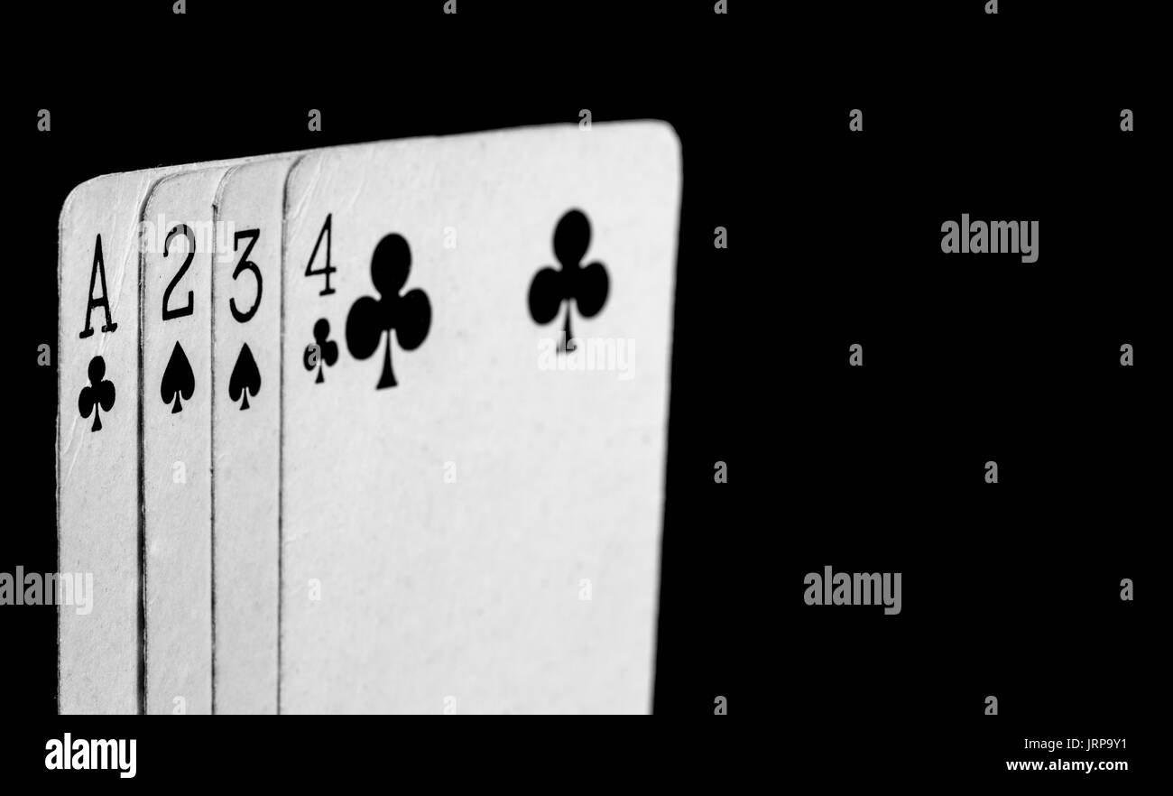 White playing cards with black symbols on a black background Stock Photo