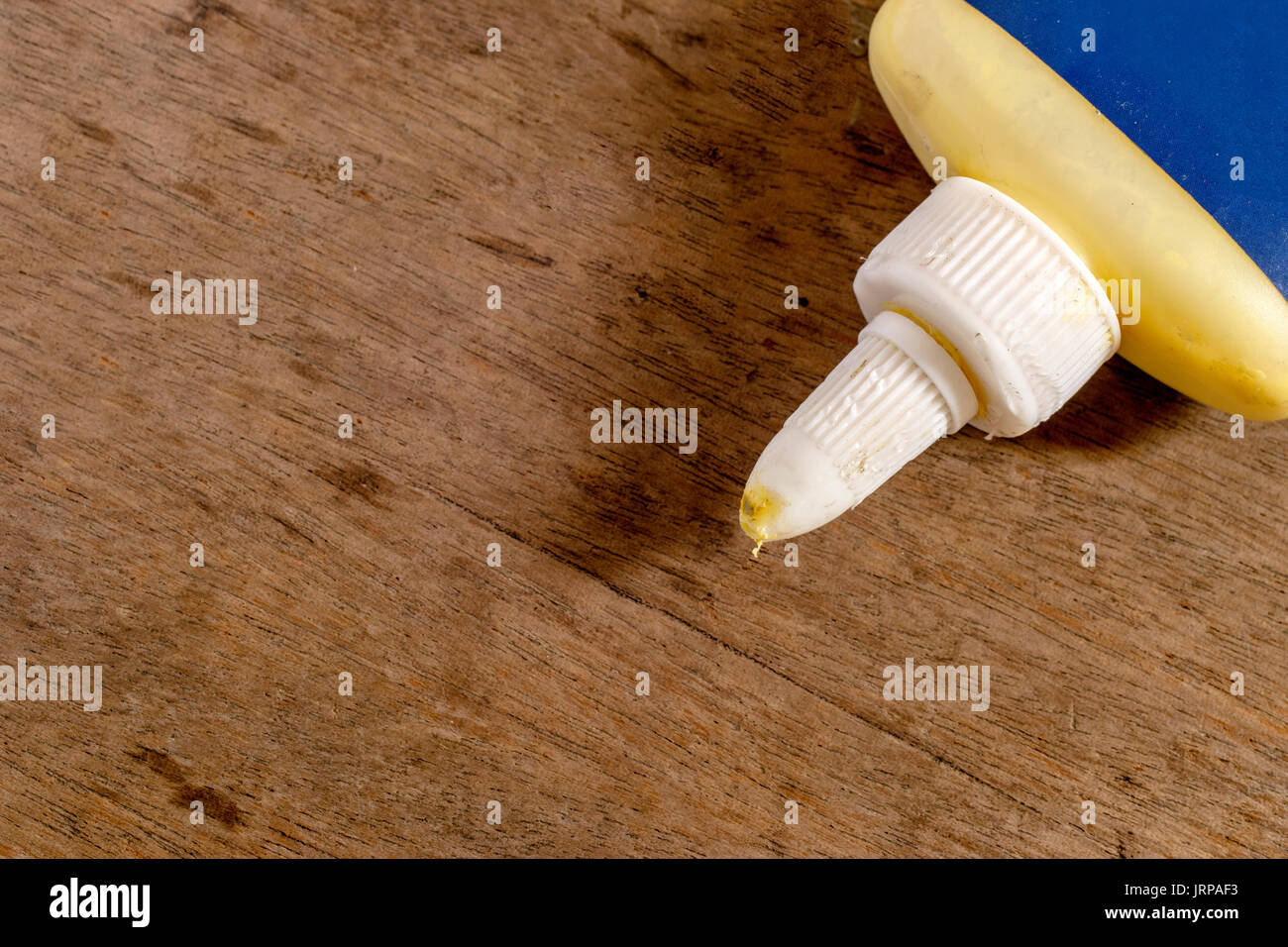 Wood glue with blank blue label on a wooden surface Stock Photo