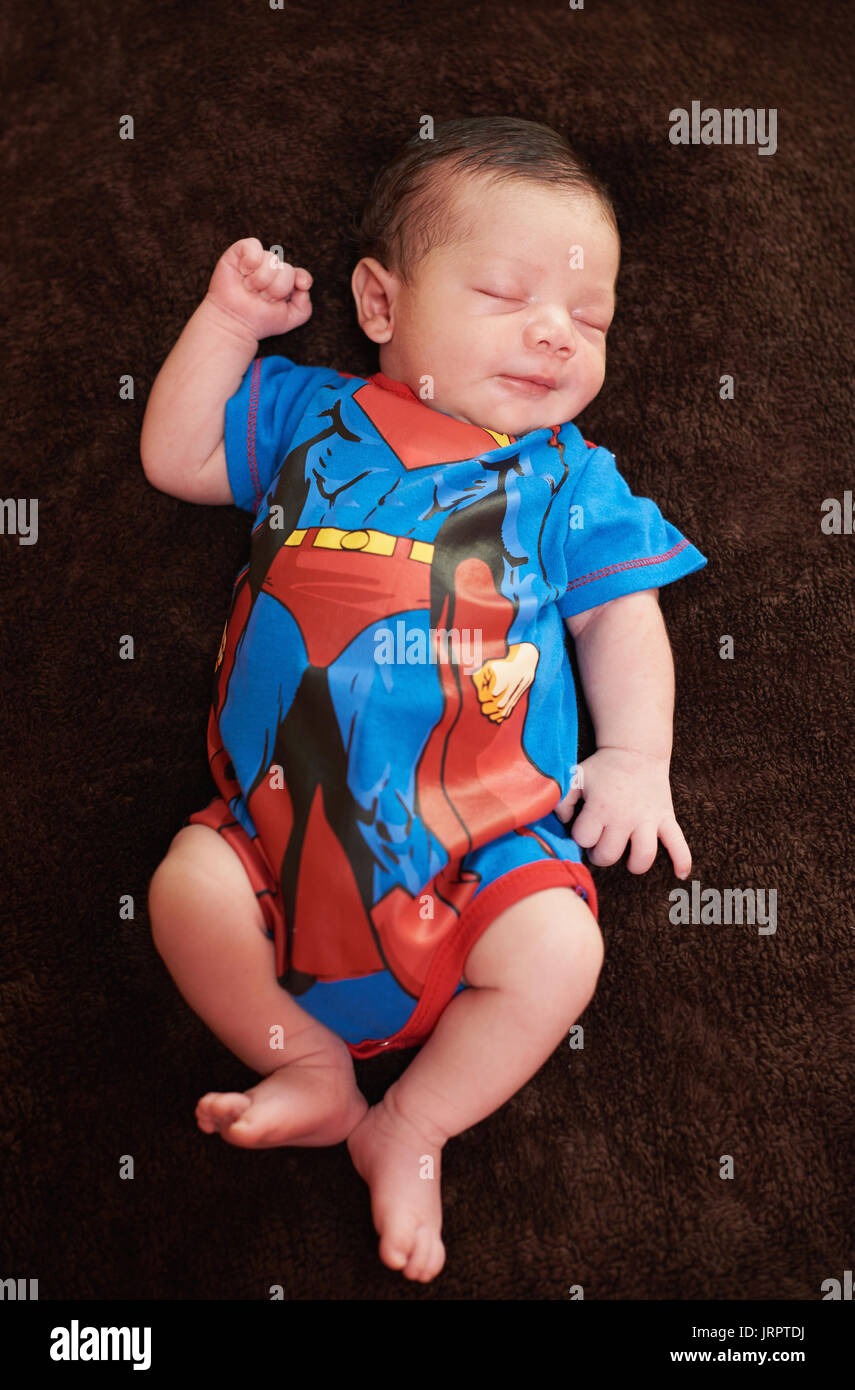 Newborn in costume outfit sleeping in blanket Stock Photo