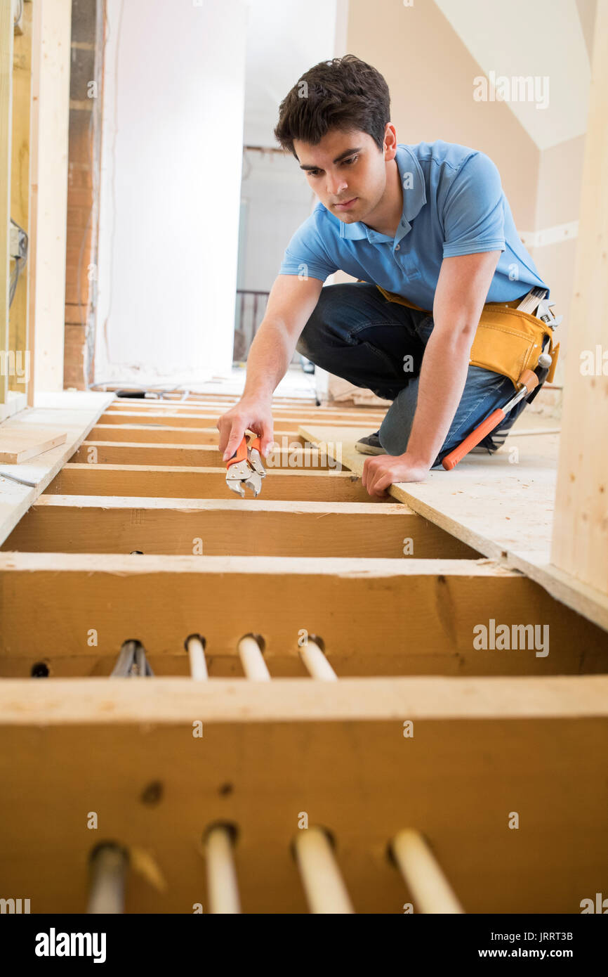 Apprentice Plumber Fitting Central Heating System In House Stock Photo