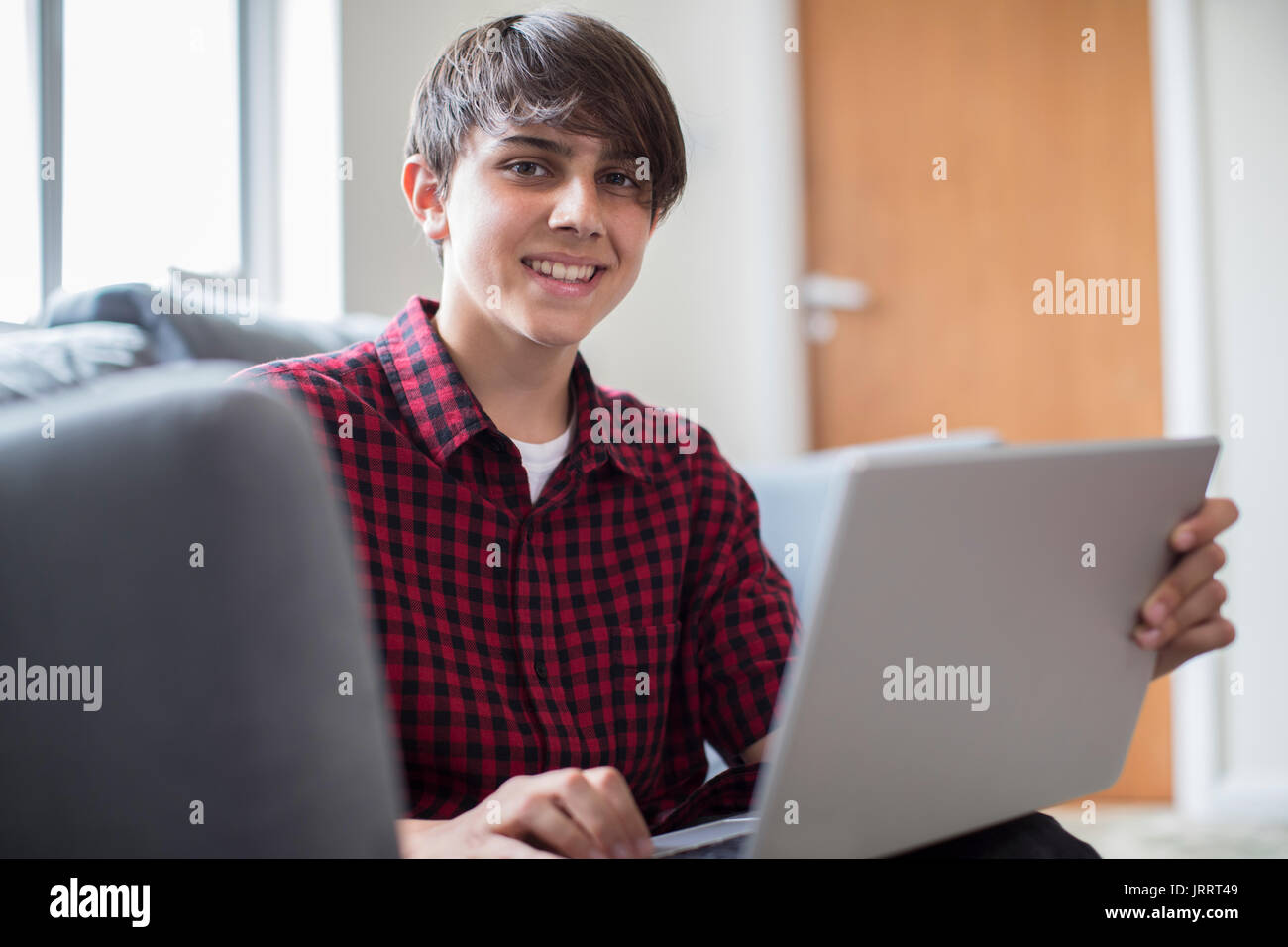 Portrait Of Teenage Boy Working On Laptop At Home Stock Photo