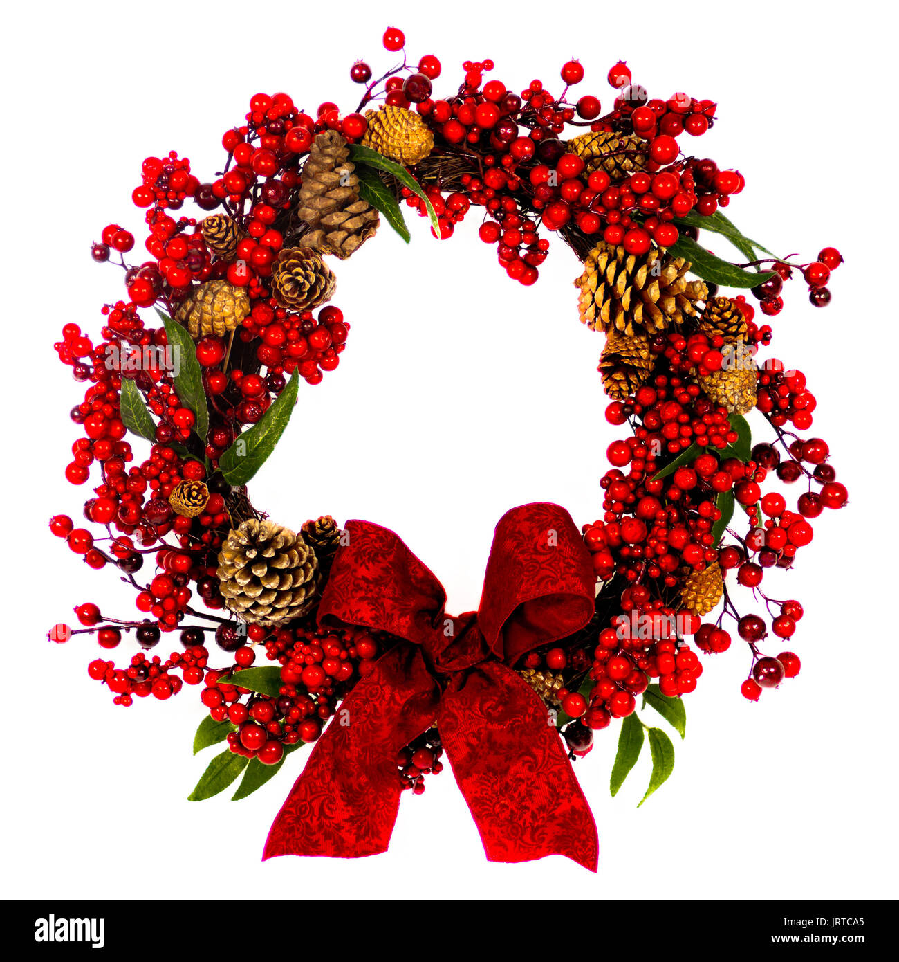 A brown twig wreath is decorated with red berries, pine cones and a red ...