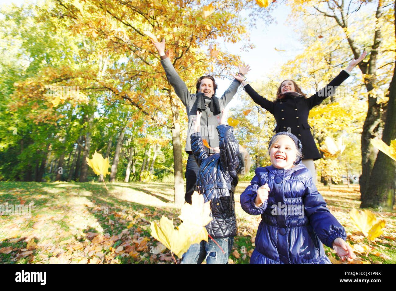 Happy family playing with autumn maple leaves in park Stock Photo - Alamy
