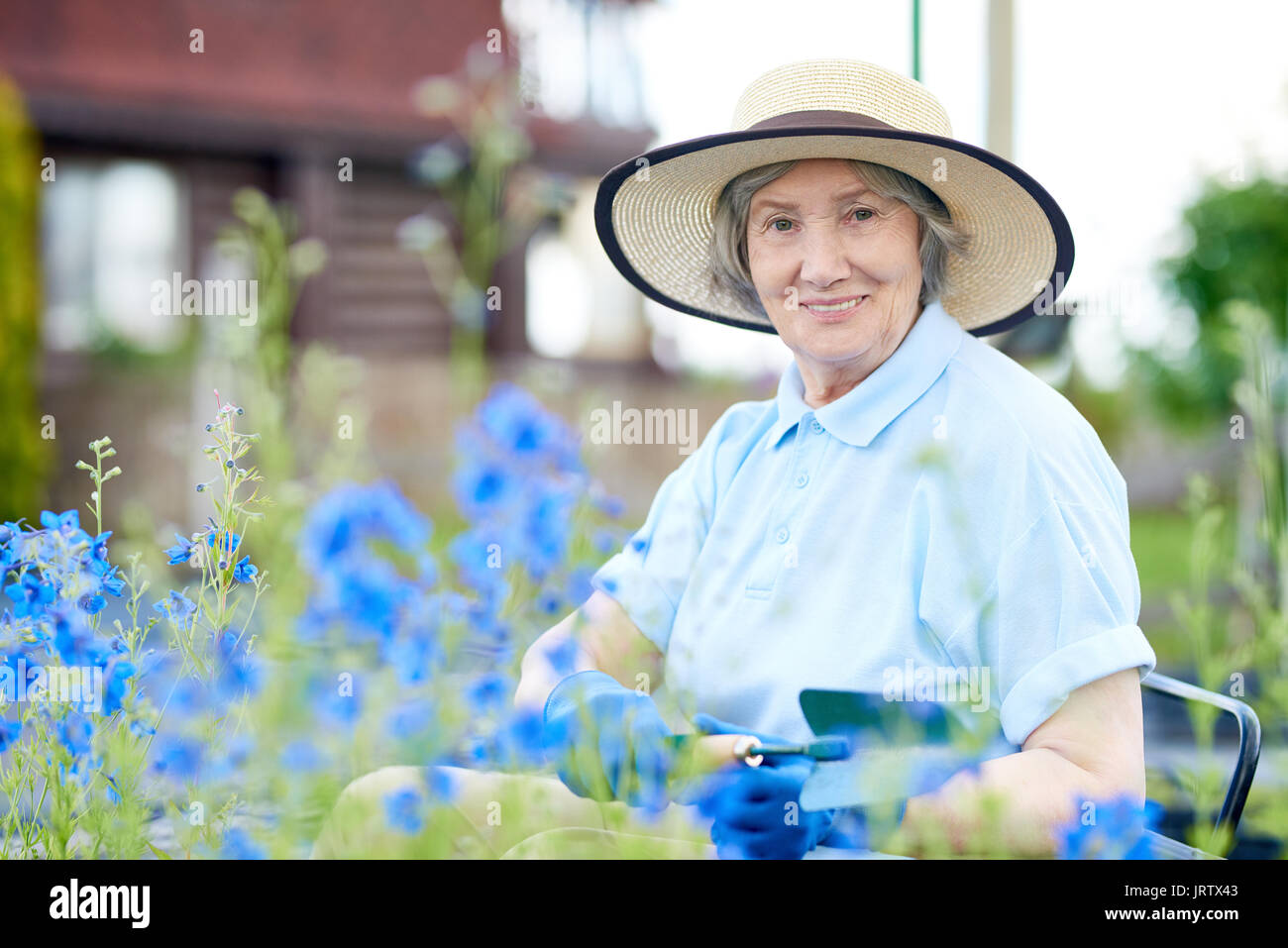 Happy Senior Woman Planting Flowers in Garden Stock Photo - Alamy