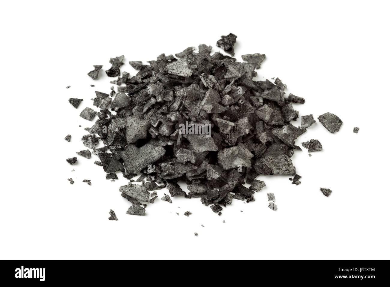 Heap of black flakes on white background Stock Photo
