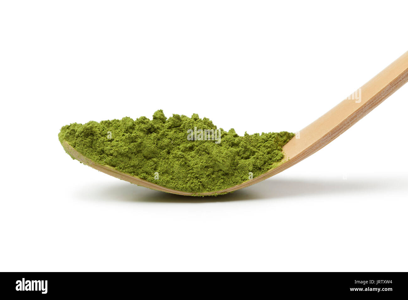 Japanese bamboo matcha spoon, chashaku, with green tea on white background Stock Photo
