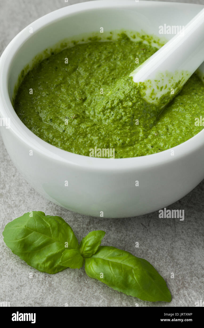 Green homemade Italian pesto in a mortar Stock Photo