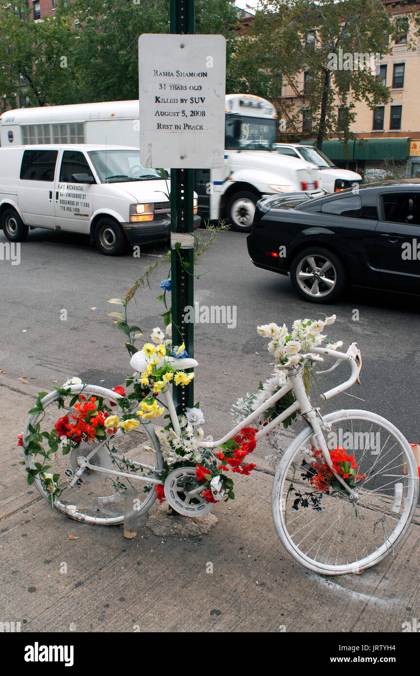 A bicycle painted white chained to a pole in memorial of a bicycle accident. Manhattan, New York City, Unites States. Stock Photo