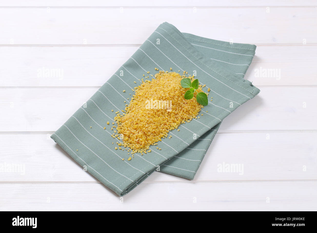 pile of dry wheat bulgur on grey place mat Stock Photo