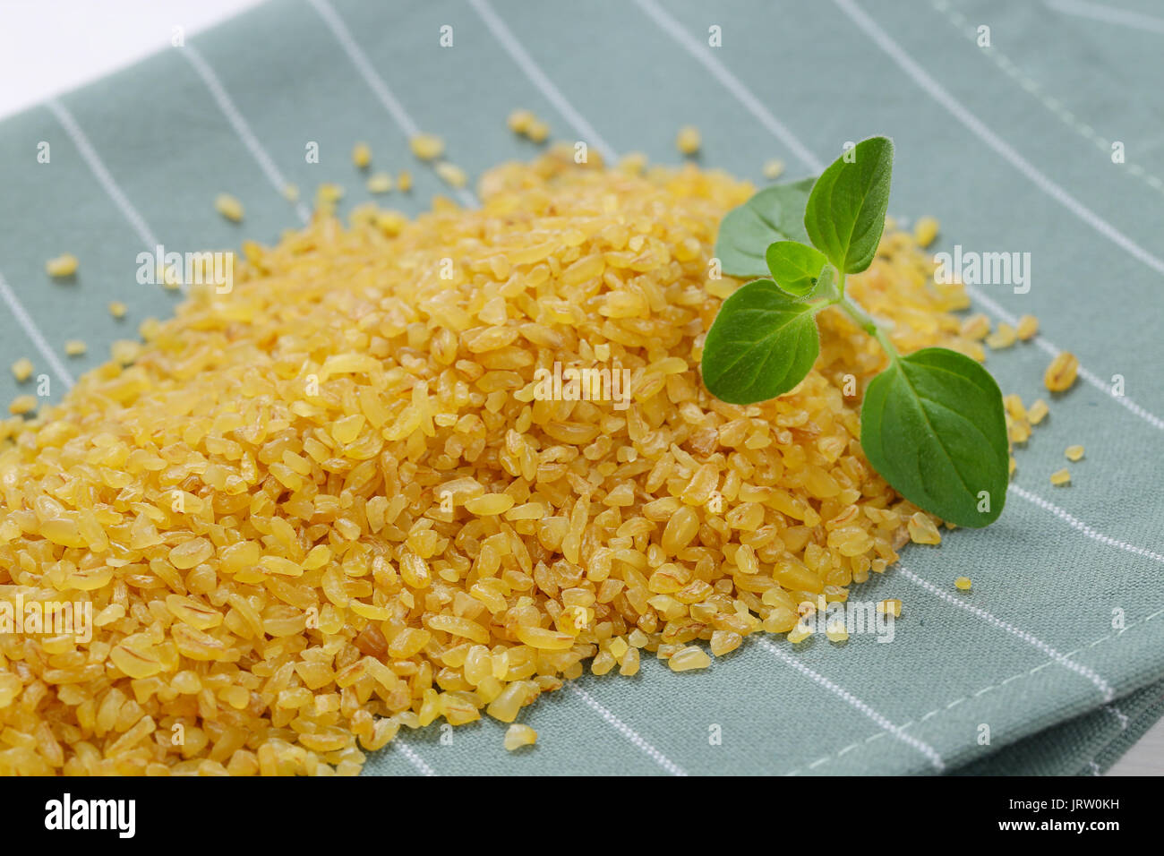 pile of dry wheat bulgur on grey place mat - close up Stock Photo