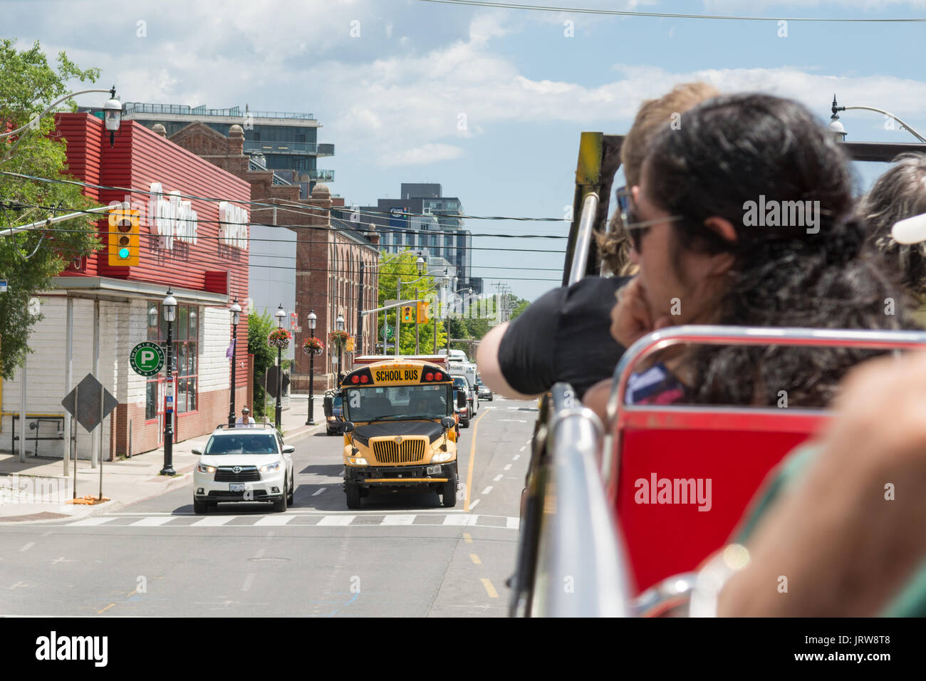 tourists on Toronto open top bus tour looking at School Bus, Canada