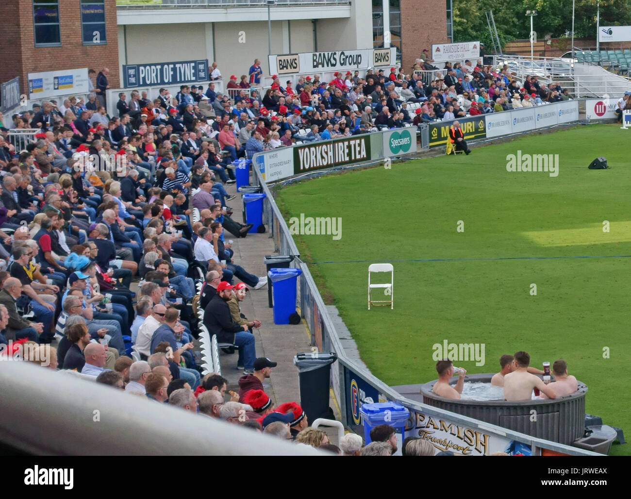 Spectators drinking beer in hot tub at cricket match, Chester-le-Street, England Stock Photo