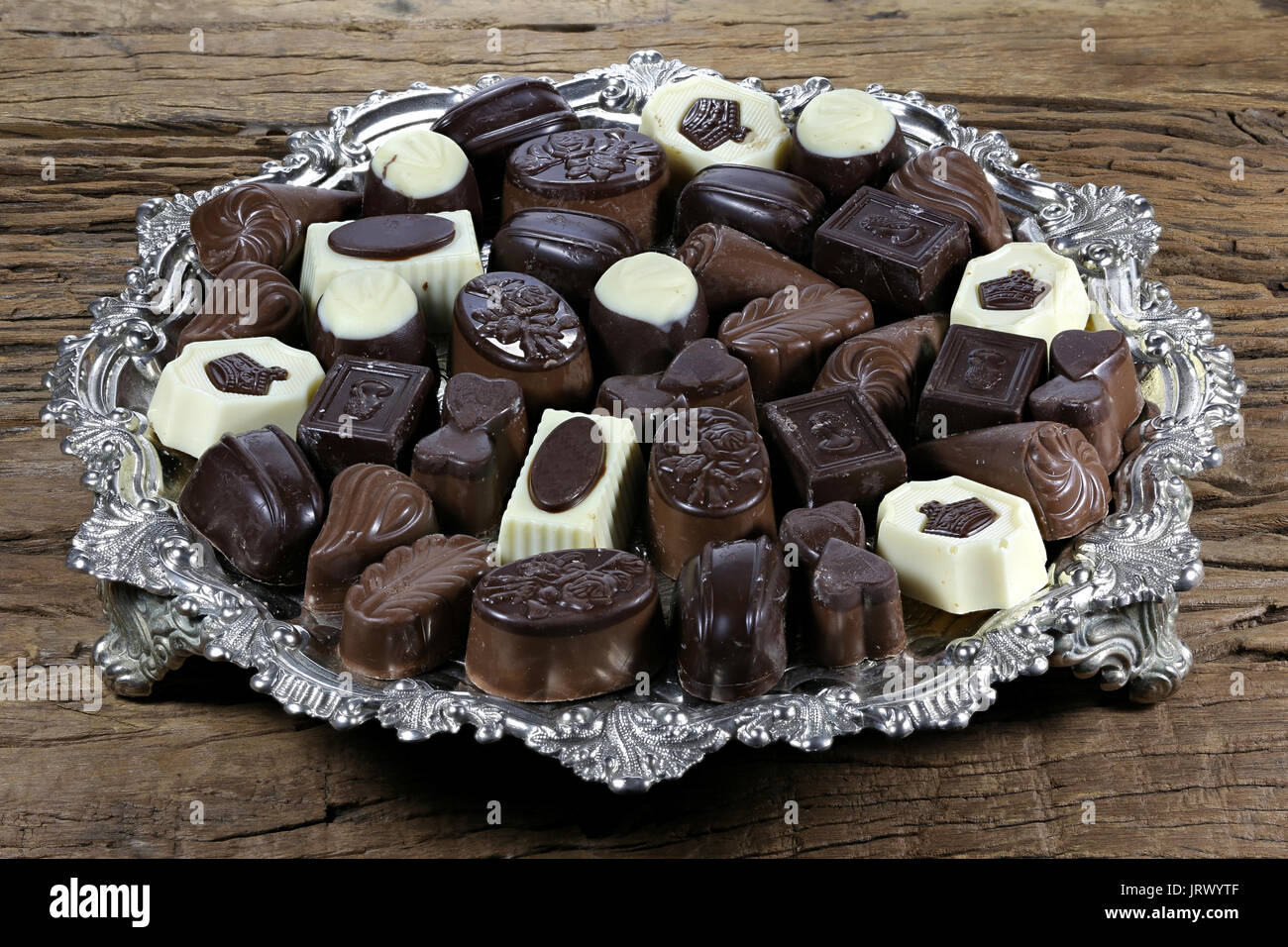 silver tray with Belgian chocolate pralines on rustic wooden background Stock Photo