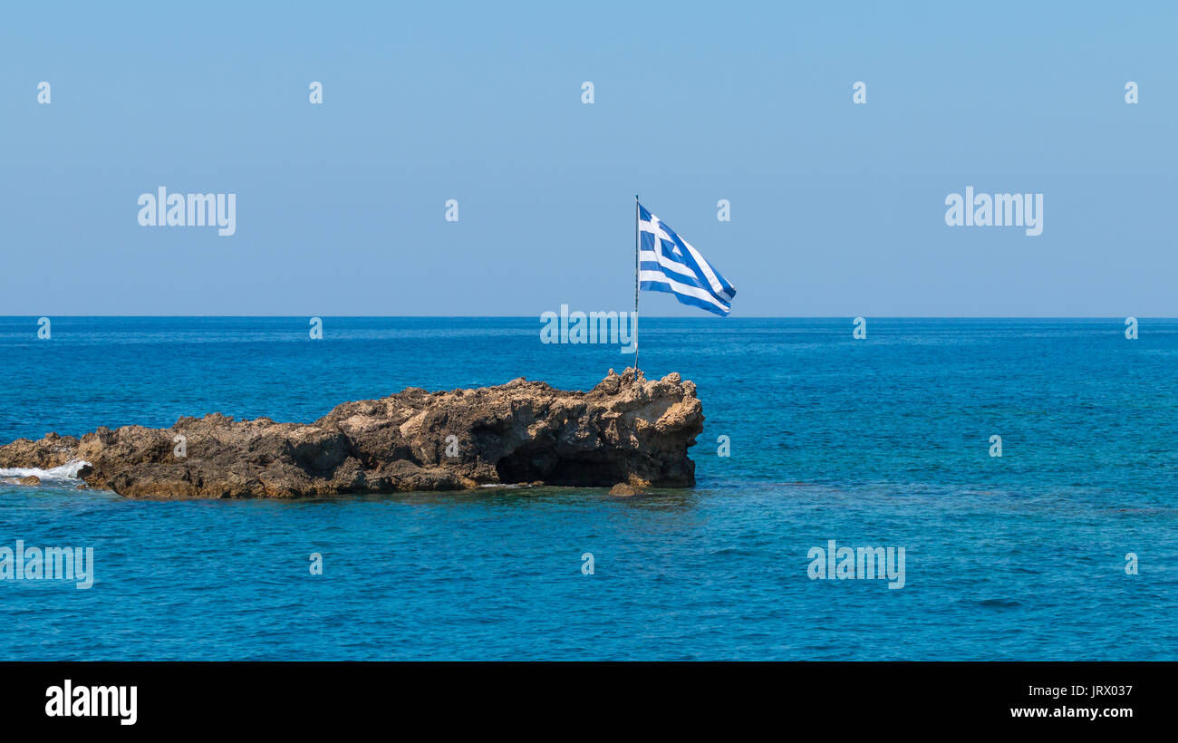 greek flag on a small rocky island Stock Photo