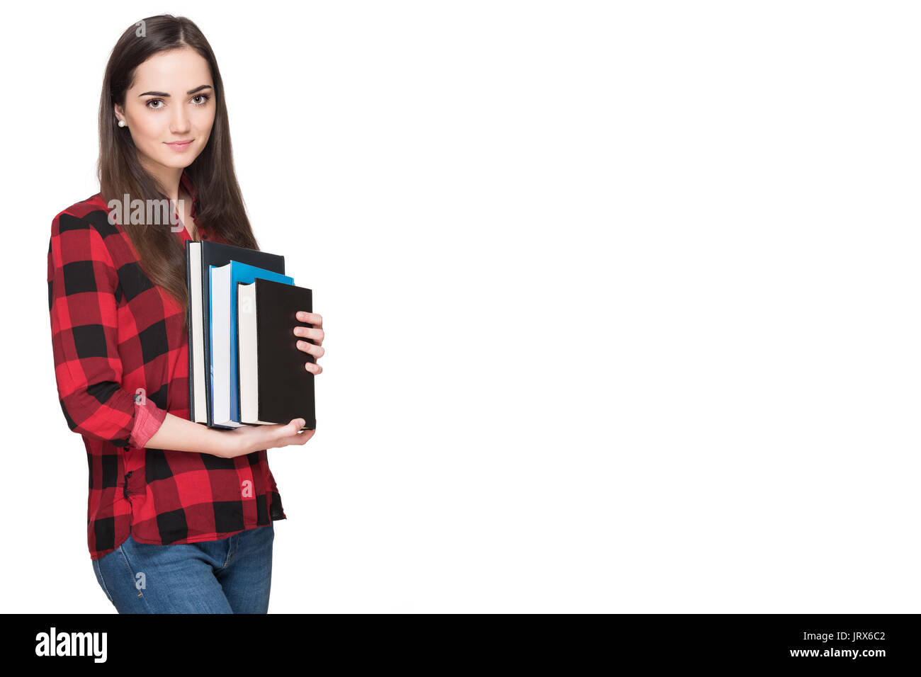 Happy student life. Attractive cheerful young female student holding books, isolated on white background. Stock Photo