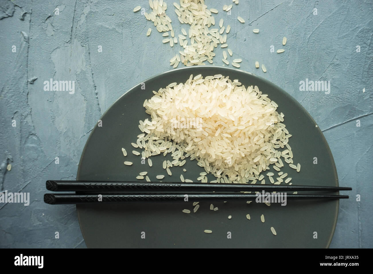 Porcelain plate and rice on grey concrete table with copyspace Stock ...