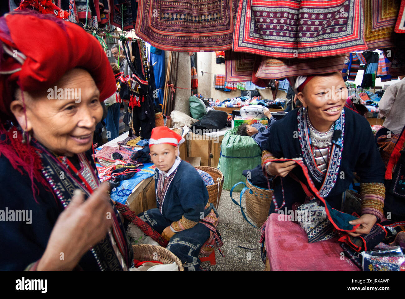Red dao hmong women make and sell tribal handicrafts and clothes iniside the market in Sapa, Lao Cai Province, Vietnam Stock Photo