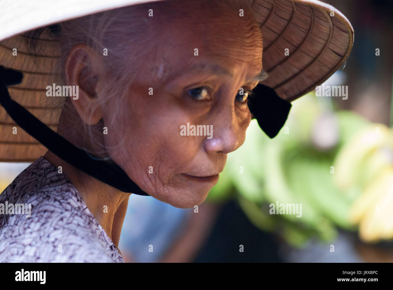 Woman wearing traditional hat, Hoi An, Vietnam Stock Photo