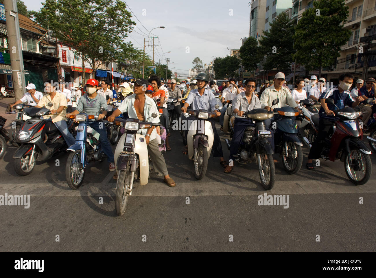 Hundreds of motorists are waiting for a traffic light to turn green on a street in Ho Chi Minh City, Saigon, Vietnam. Motorbikes at a busy junction in Stock Photo