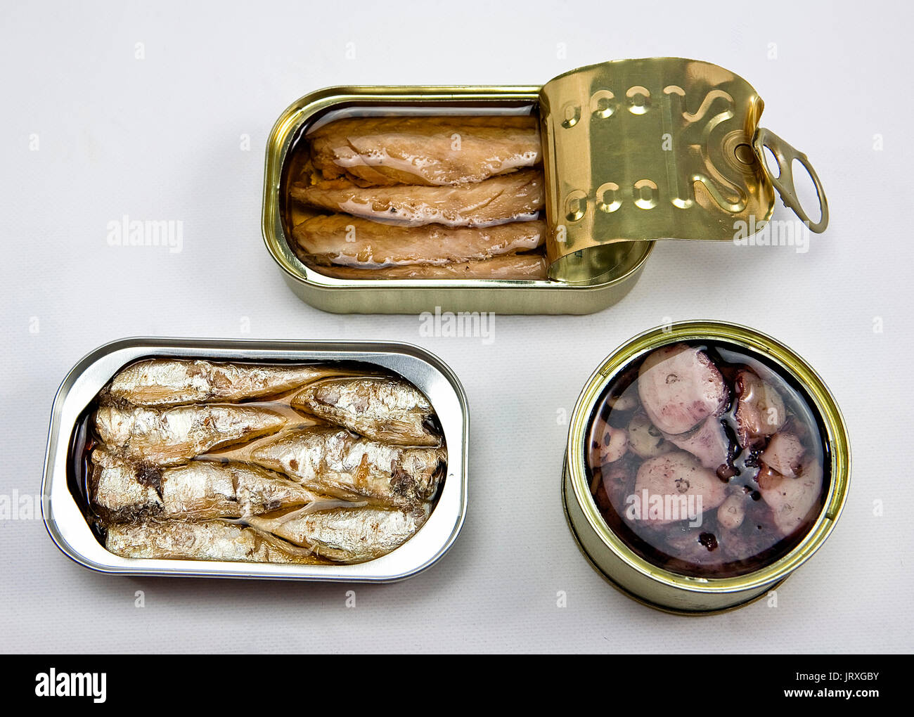 Tins of different sizes and opening, mackerel in vegetable oil, sardines and Octopus Stock Photo