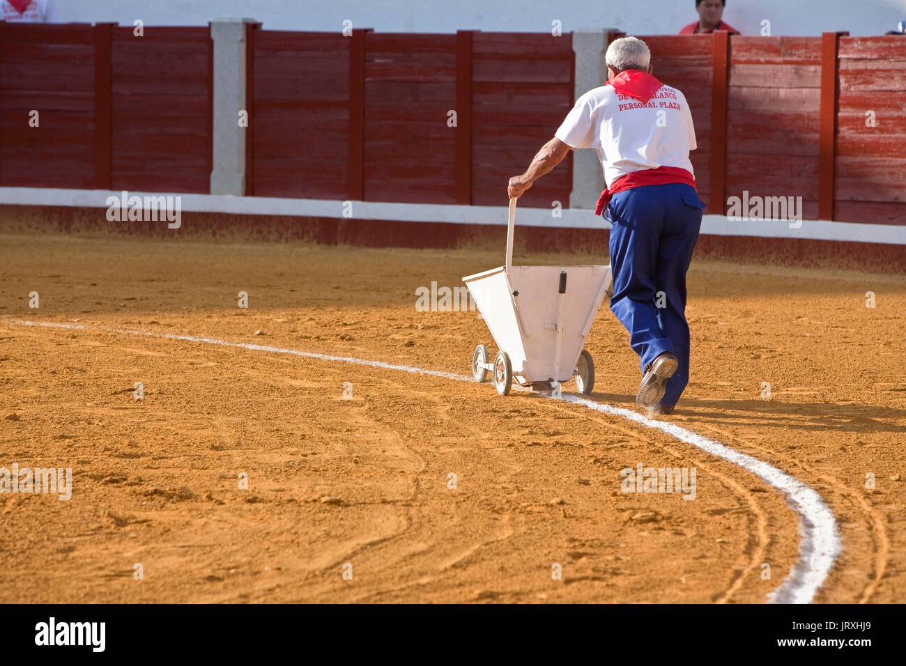 employee of the Bullring painting with a machine the white line of the bullring, Pozoblanco, Spain Stock Photo