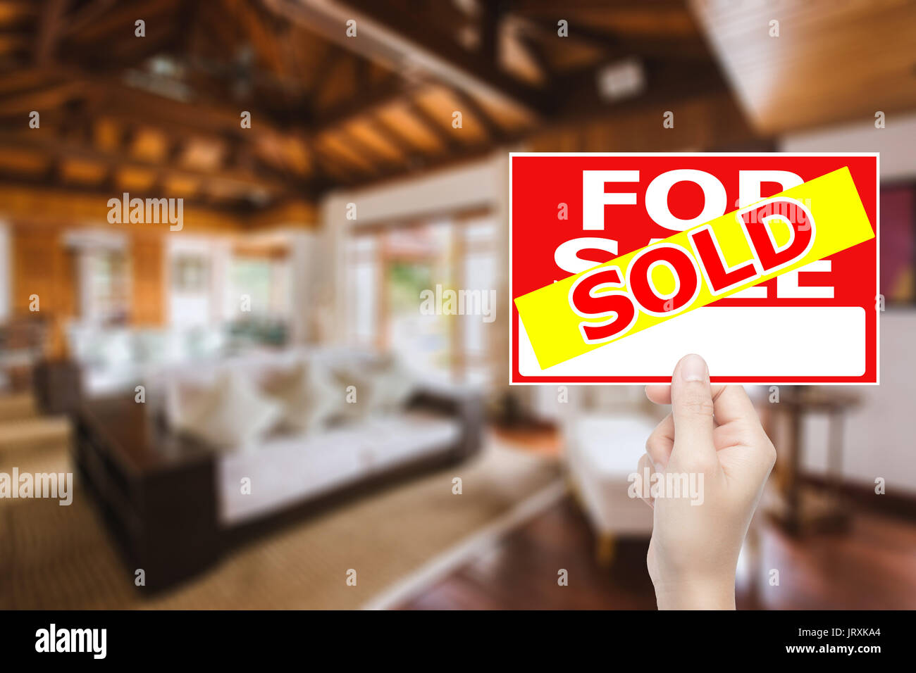 hand holding sold house sign Stock Photo